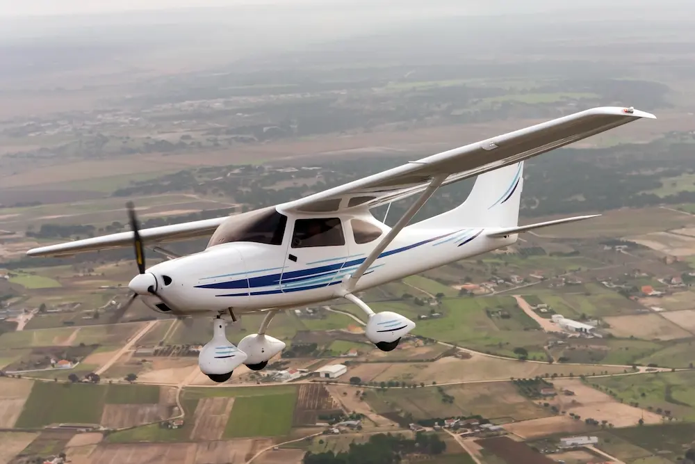 small single engine plane flying over rural area